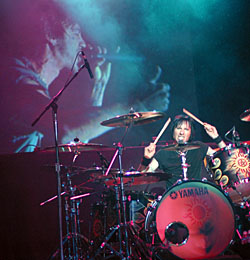 Godsmack drummer Tommy Stewart pounds skins in front of the giant screen.