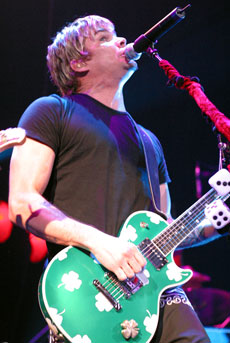 Mark McGrath sings while jamming on his guitar.