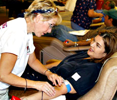 Registered nurse Carol Cavanaugh puts a needle in Elaine McNearney´s arm to draw McNearney´s fifth gallon of blood. The blood drive was held Sept. 11 at Houchin Blood Bank on Truxtun Avenue.