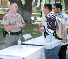 Officer Greg Williams of the Highway Patrol talks to BC students Gehaiman Saef, left, and Wathah Muthare.