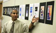 Shafik, a graphic arts instructor, shows off student projects from one of his classes.