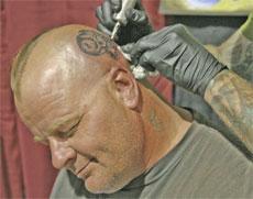 Blair Young gets a skull tattoo on his head by tattoo artist Aaron hodges at the expo.