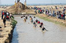 Competitors race to the finish line toward the end of the 2006 Volkslauf Mud Run. The competitors sloshed through 5 million gallons of mud and water.