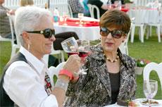 Ronda Mazzei (left) and Joyce Downs (right) enjoy a sip of red wine while sampling the array of hors doeurvres.