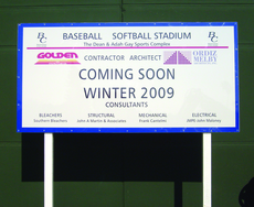 A sign states completion of the baseball field in the near future.