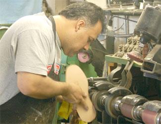 Felipe Torres, of Big Shoe Repair, works at his equipment inside the shoe-shaped building Oct 13. Torres took over the building in 2002.