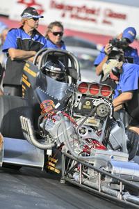 Crew members make last minute adjustments to a car at the NHRA Hot Rod Reunion on Oct 18.