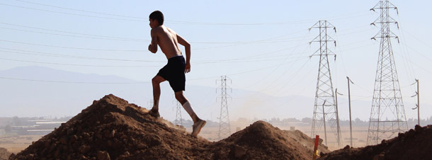 A participant runs up a pile of dirt at the annual Volkslauf Mud Run