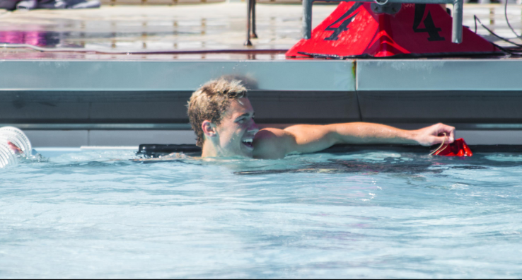 Sophomore Brian Bender chats with a swimmer in another lane (not pictured) after defeating his opponent in the 50-yard freestyle against Clovis Community College on March 25.