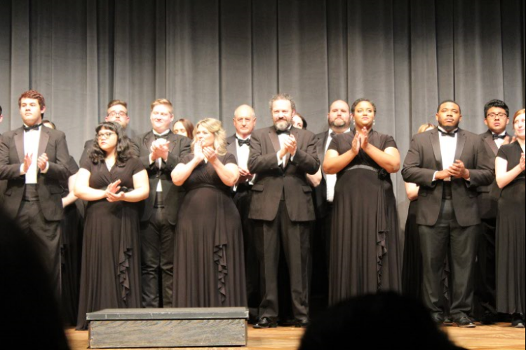 The Bakersfield College Chamber Singers clap along to the music as they perform.