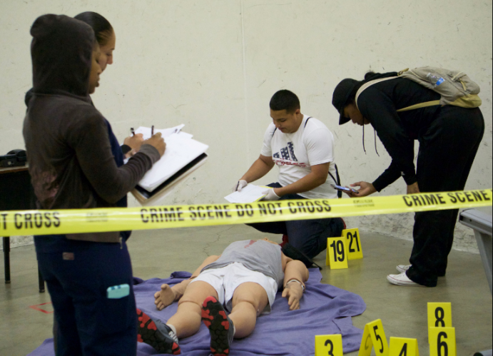 From left to right: Emm West, Naomi Valladares, Richard Tovar and Elexus Thurman examine the mock murder scene on March 23.