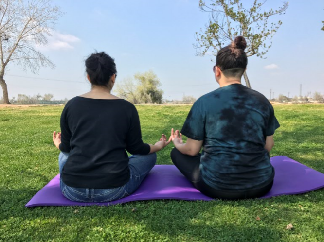 Ana Lopez and Joanna Davis practice their meditation techniques at Riverwalk Park.