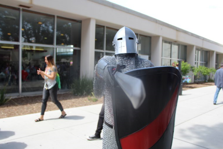 The Bakersfield College knight mascot directs people waiting in line for free ice cream to step back by pointing a sword at them on April 3 during Spring Fling.