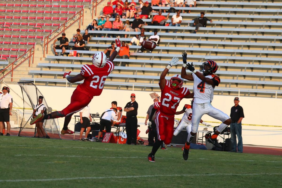 BC Renegade football players Ernest Harris, number 26, and Louis Early, number 27, jump to intercept Riverside Tiger football player Malik Holcomb, number 4, from catching a pass.
