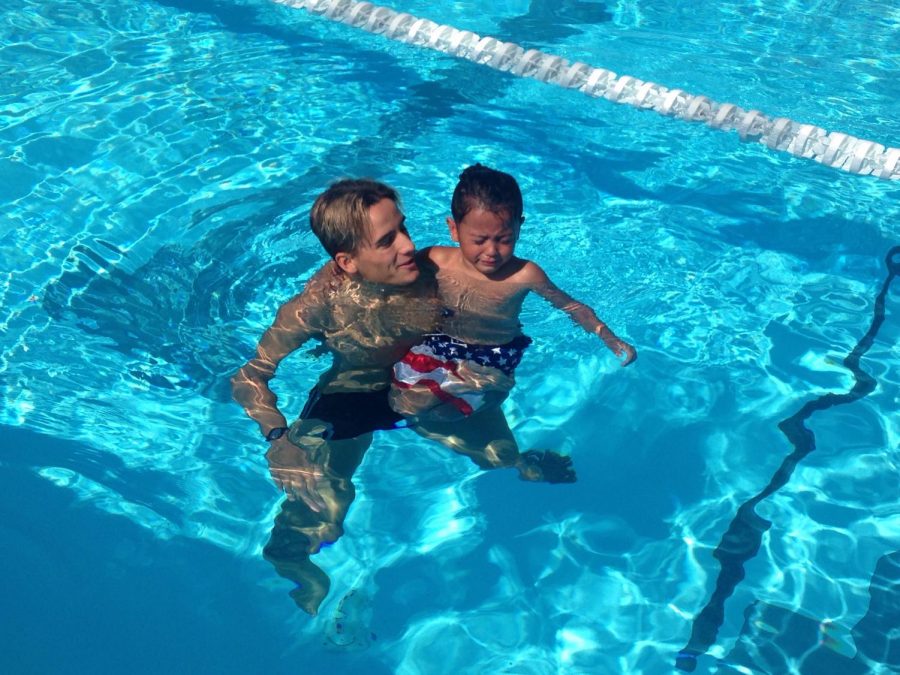 Tanner Lopes, a member of the Bakersfield College swim team teaches Braylen Davis how to be comfortable in the water.