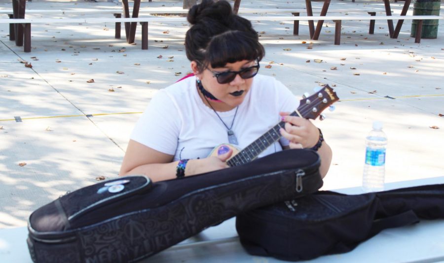Kelsey+Morrow+checks+her+ukulele+before+going+up+on+stage+to+open+at+Pride+Fest.