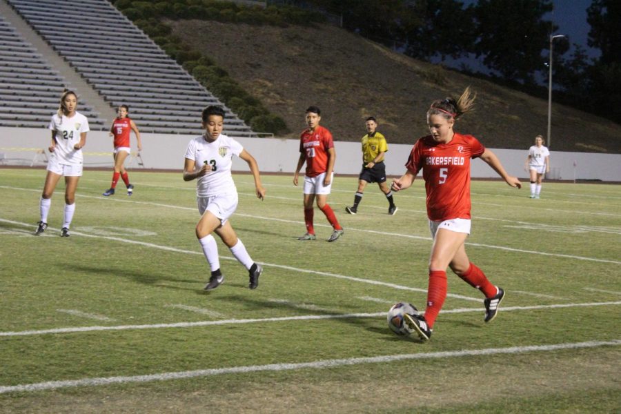 Delaney Boyer is followed by a LA Valley player as she travels the ball toward the opposing teams goal box.