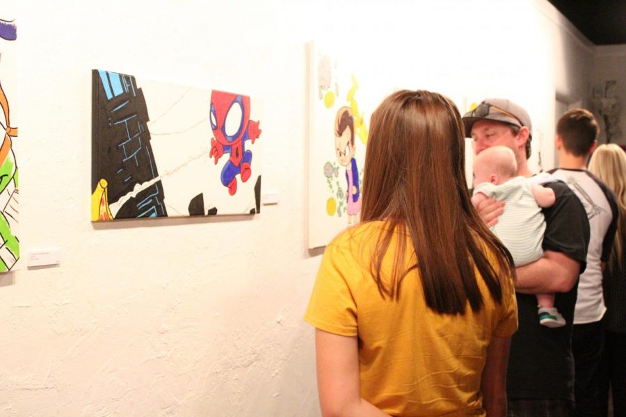 Guests gaze at the artwork of Jason T. Stewart at the Empty Space art exhibit on Sept. 9.