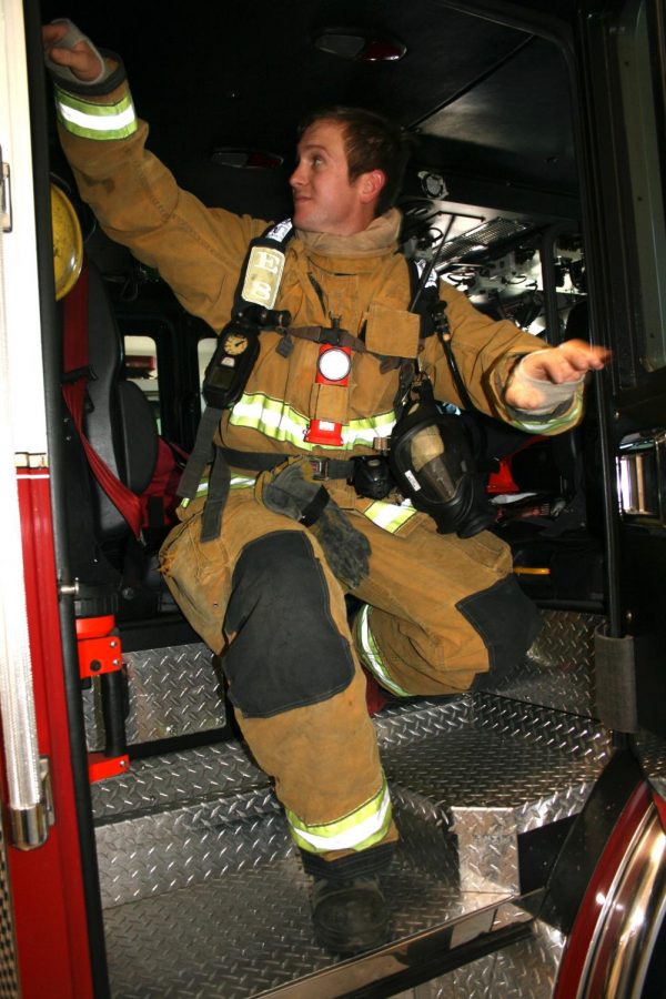 Firefighter Bill Ballard climbs out of a fire engine after demonstrating the routine of responding to a fire call.