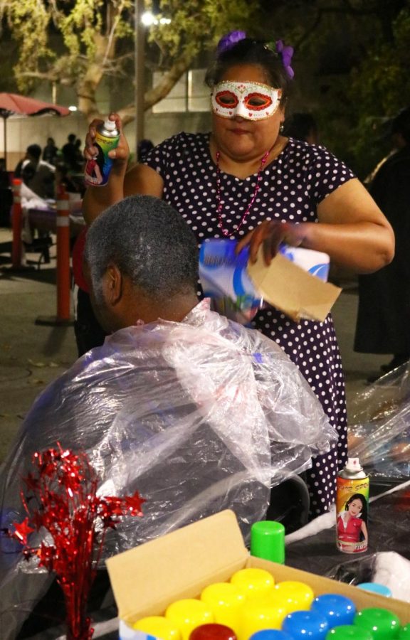 Volunteer Belinda Lopez Rickett at the Masquerade Ball
spray paints Jeremey Randall’s hair a variety of colors.