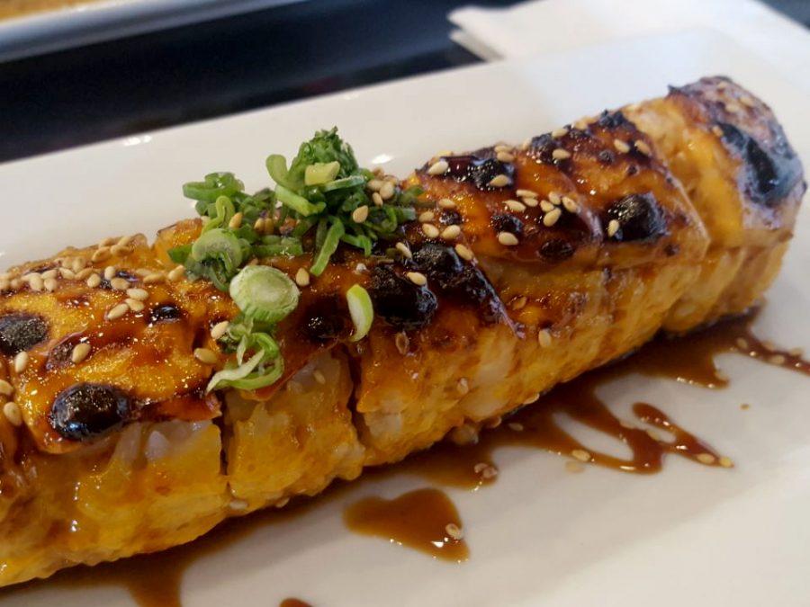 The Baked Salmon Roll dish served at Bocado’s Sushi Bar contains salmon, cucumber, crab meat, and cream cheese. 