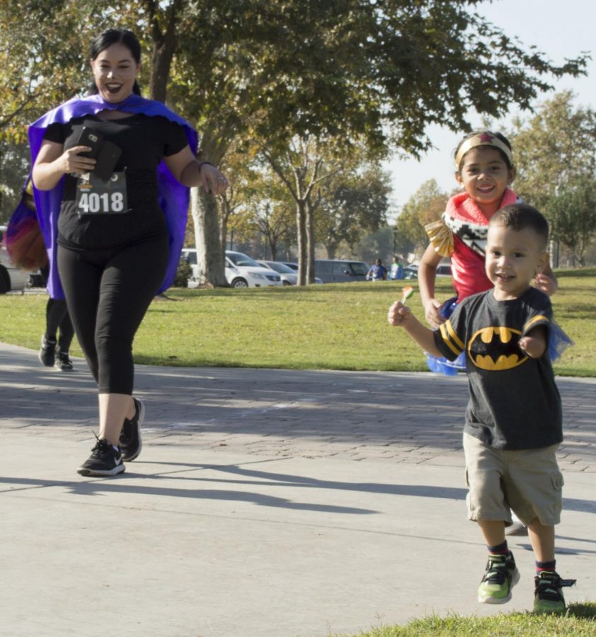 Danna Lopez and her two children, Yareti Lopez and Saul Lopez, smile as they cross the
5k finish line at the Haunted Hustle at the Park at Riverwalk on Oct. 28.