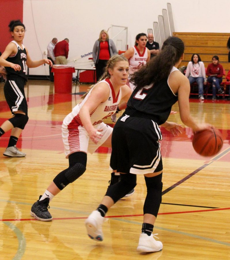 Angie Kroger, BC Renegade player and guard on the basketball team, facing off against a player from Los Angeles Pierce College