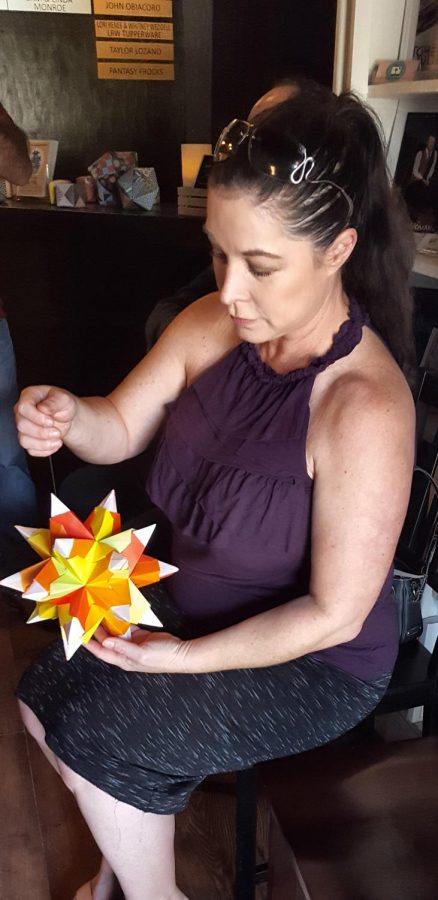 Jennifer Folkert, attendee of the gallery, looks at her geometrix star piece.
