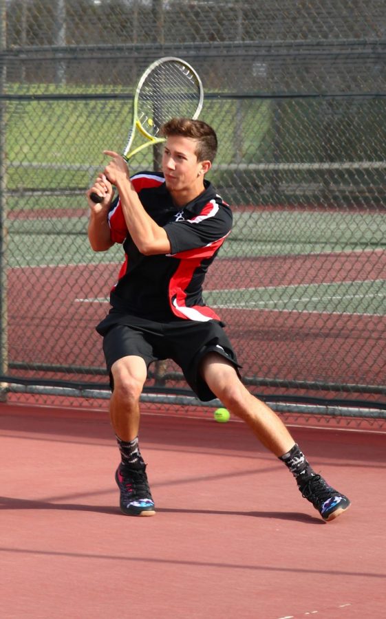 Kaleb Johnson during his singles game against Ventura College as he returns the ball over the net. 