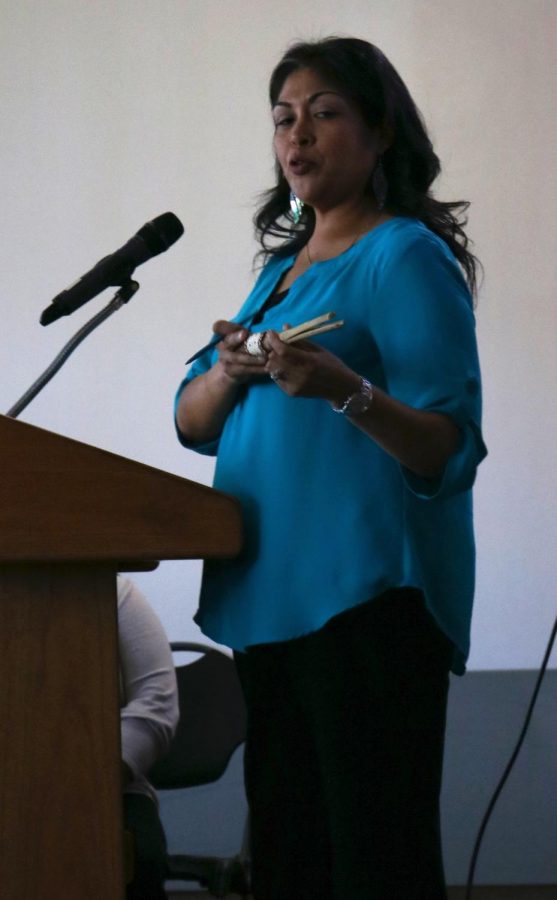 During the Tejon Tribe: Past and Present Presentation at Bakersfield College, Sandra Hernandez shows the audience a clapper sticks, a traditional instrument used by the Tejon Tribe. 