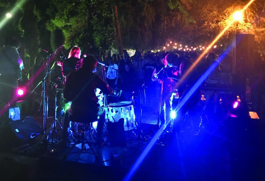 A crowd gathers around Sugar Candy Mountain as they perform during the Art After Dark Summer Concert.