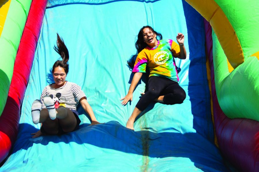 Sheila Kolodji and Dominique Harrison slide down the obstacle course on Aug. 28.