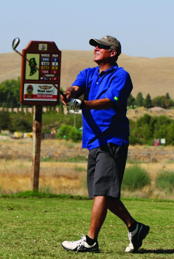 Richard Bumatay watches his golf ball after his swing.