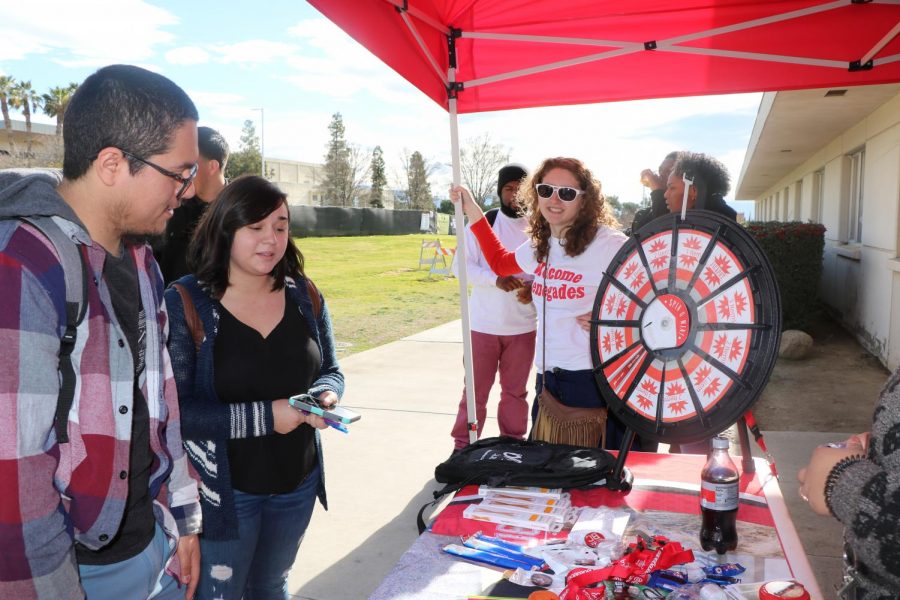 Anthony Acevedo and Naomi Acevedo choose their prizes after spinning the wheel, while ASB member, Elisabeth Sampson (back) looks on.