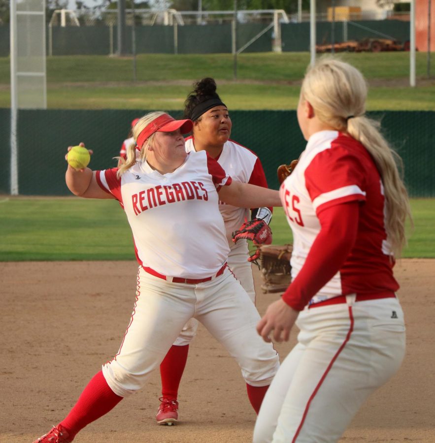 Alantis Rede (furthest back) and Natilee Parrish (close front) watching starter pitcher Kylee Fahy throwing out a bunt ball to first, on March 23.