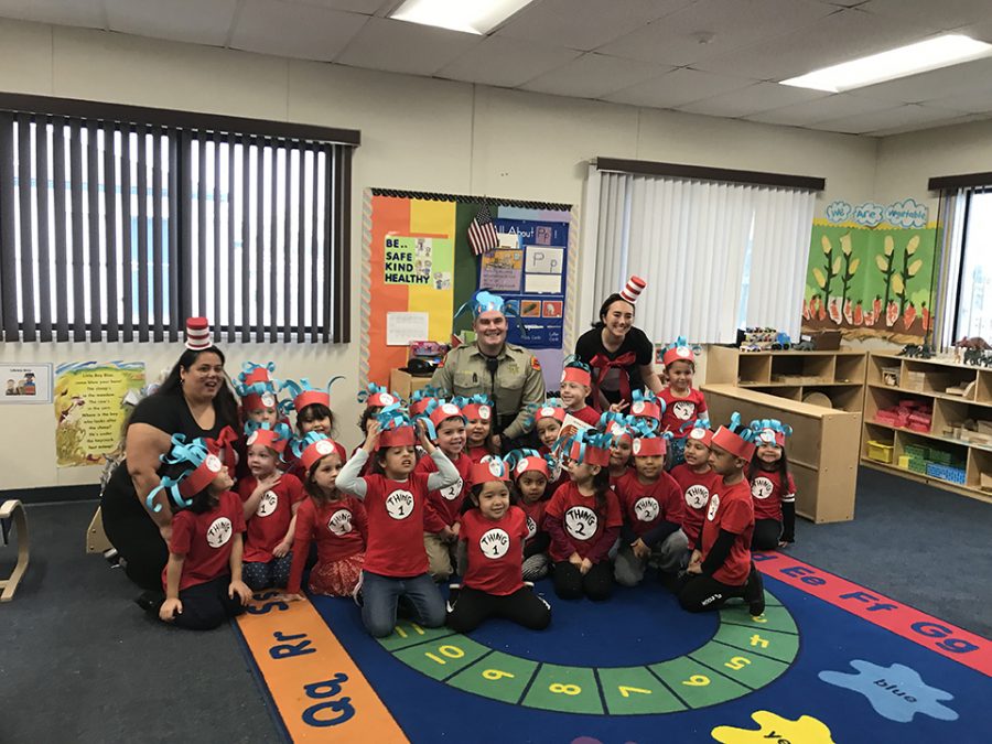 Edison Pre-School classroom takes a photo with their volunteer reader after finishing a book.