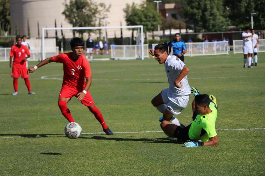 As Armando Alvarez (1) slides to reach the ball, he just misses by an inch running into a player from Antelope Valley, while Edgar Gonzalez rushes to steal the ball before the Antelope Valley player reaches it.