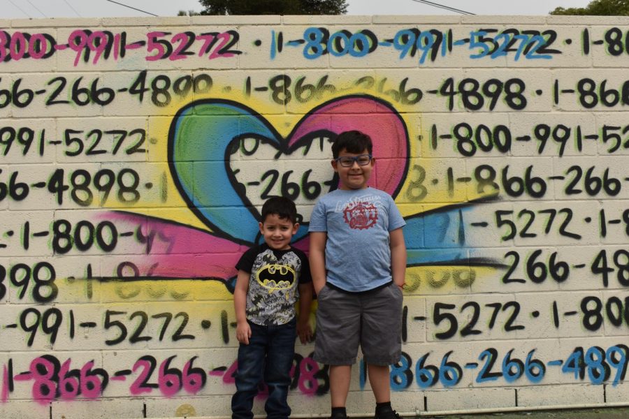 Maverick (left) and Makakai Gonzalez (right) with their father, Hugo Gonzalezs mural. 