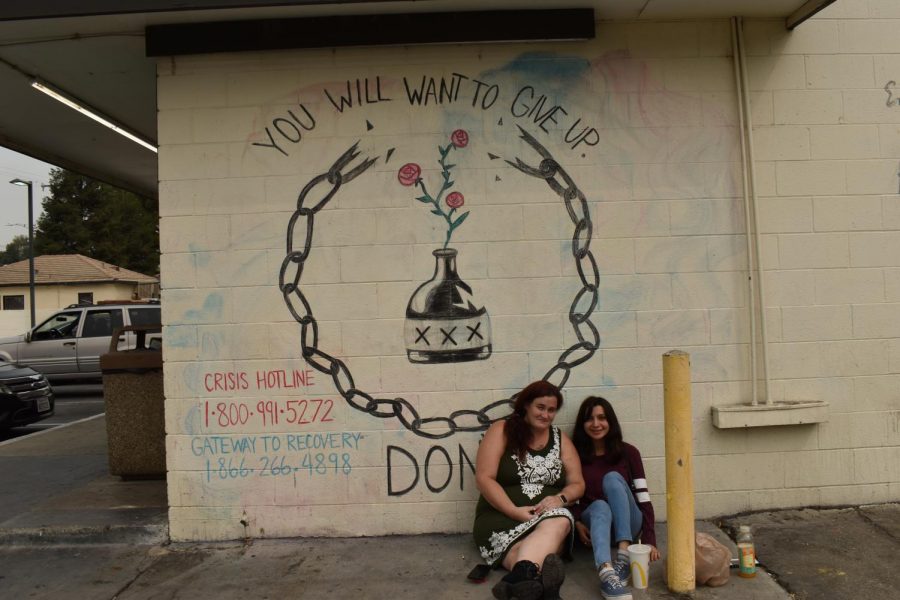 Sarah Collver and Erica Toledo with one of the the several murals part of the Chalk Walk Scavenger Hunt on Sept. 11. 