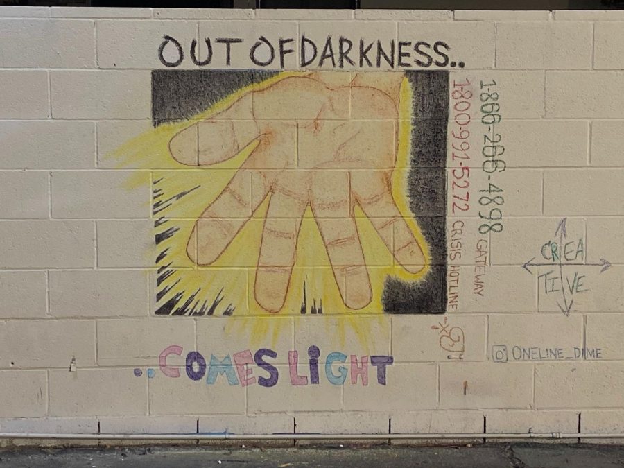 A mural located on Chester lane created by Jennifer Jamie. Located to the right of the mural are the numbers to the crisis and gateway hotline.