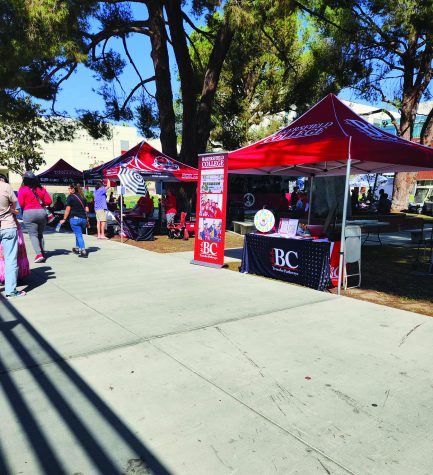 three red canopied booths along a walkway on Bakersfield College campus