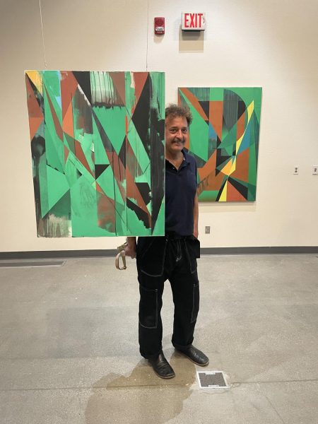Jaime Gili posing in between two pieces of his “Monte” collection inside of the Wylie and May Louise Jones Art Gallery 