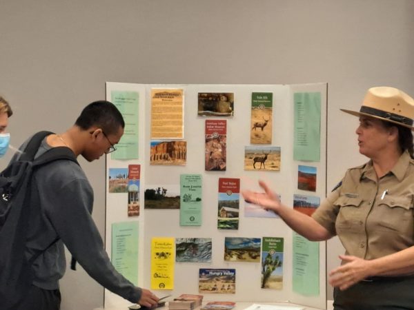 Jerilyn showcases her poster of all the parks in the surrounding area while a student picks up a brochure.

