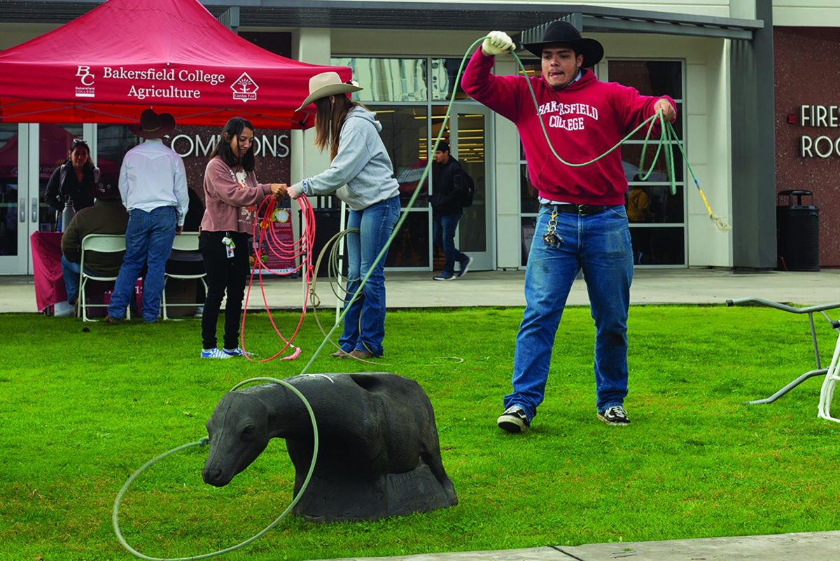 Jesus Renter showing off his lasso skills at the Rodeo Team table during Campus Rush.