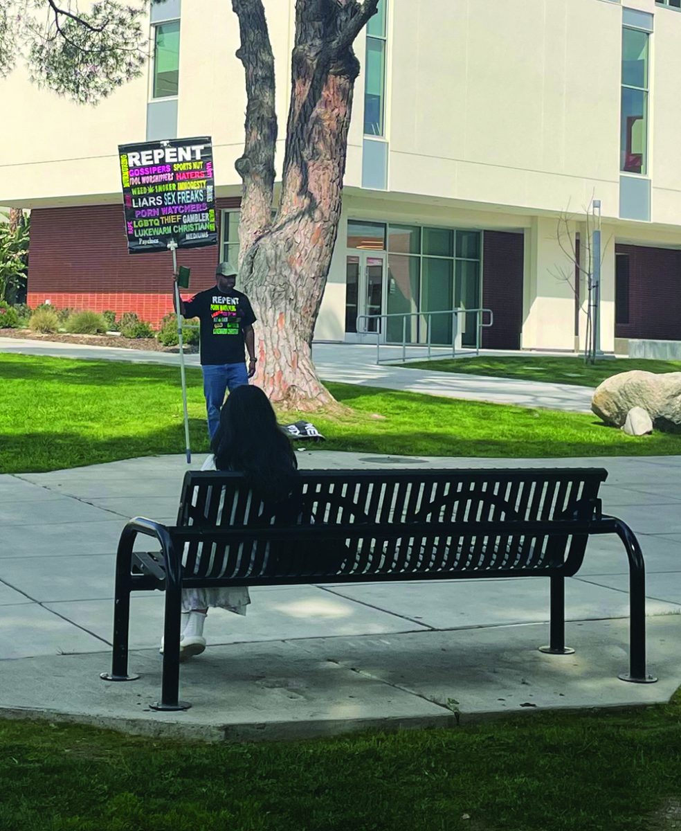 A man holding a sign proclaiming his beliefs at BCs campus.