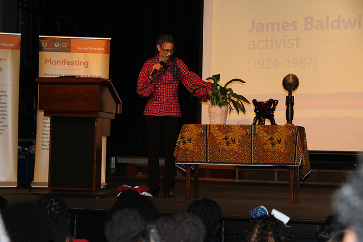 Dr. Parks pours water in ceremony to honor ancestors at the Umoja black history conference.