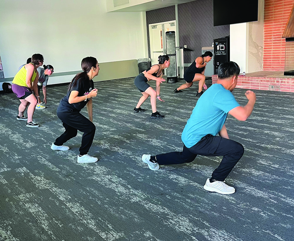 Instructor Roxane Damian(Front) guiding participants in Zumba dancing in the Fireside Room.